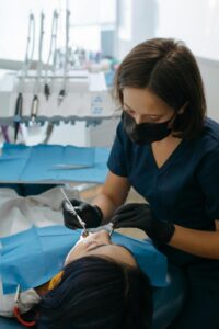 Dentist performing dental care procedure on patient in clinic setting.